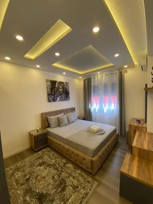 a bedroom with a king sized bed and a rug at Luxury Apartments in Ulcinj