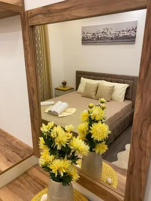 a bedroom with a bed with yellow flowers in front of a mirror at Luxury Apartments in Ulcinj