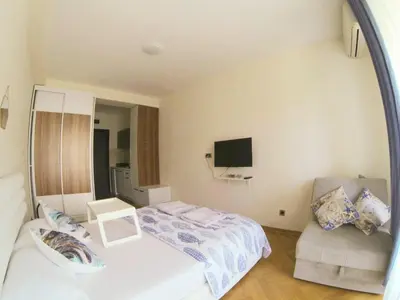 a small bedroom with a bed and a chair at Aegean home budva vojvodanska 16 b stan7 in Budva