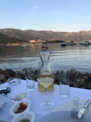 a table with a bottle of wine and two glasses at Aegean home budva vojvodanska 16 b stan7 in Budva