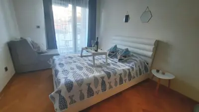 a bedroom with a bed with a table on it at Aegean home budva vojvodanska 16 b stan7 in Budva