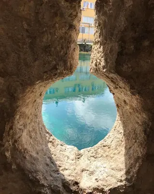 a view through a hole in a rock into the water at Aegean home budva vojvodanska 16 b stan7 in Budva
