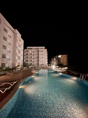 a large swimming pool at night with buildings at Apartment SONJA in Ulcinj