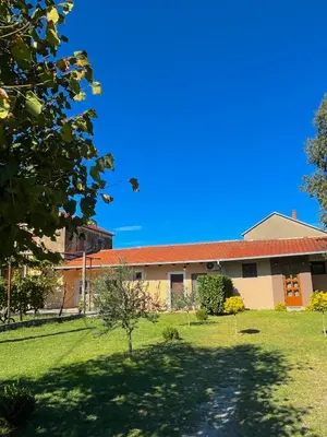 a building with a green yard in front of it at Apartman Boljević in Podgorica