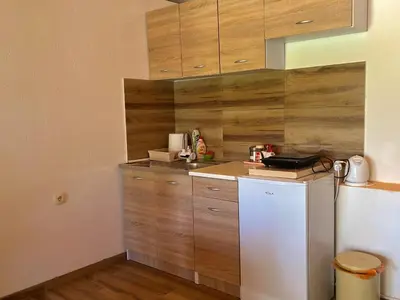 a kitchen with a white refrigerator and wooden cabinets at Apartman Boljević in Podgorica