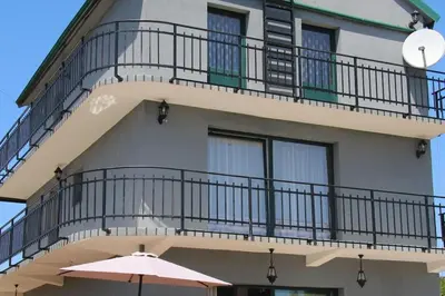 a building with a balcony and an umbrella at Villa Elena Zagora in Neodi