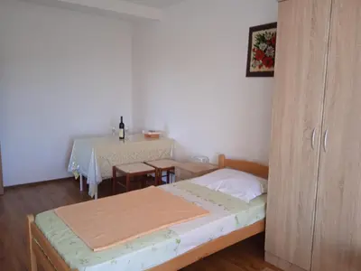 a small bedroom with a bed and a table at Villa Elena Zagora in Neodi