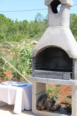 a stone oven with a table and a table at Villa Elena Zagora in Neodi