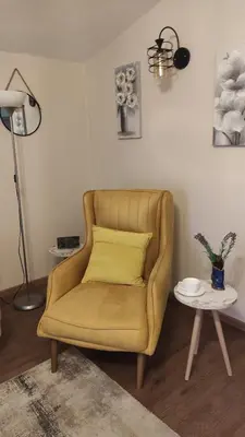 a yellow chair in a living room with a table at MASA in Bar