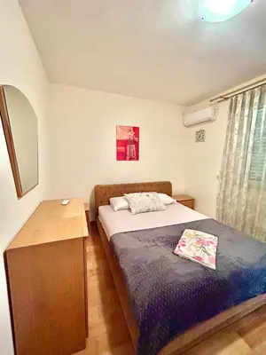 a small bedroom with a bed and a wooden table at Beach Bliss Apartment in Pržno