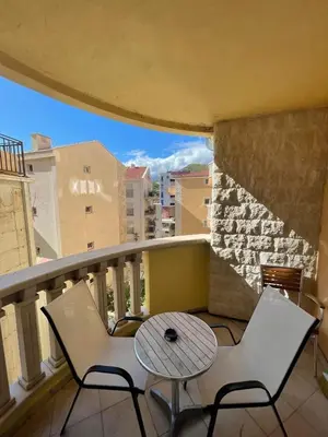 a balcony with two chairs and a table on a balcony at Beach Bliss Apartment in Pržno