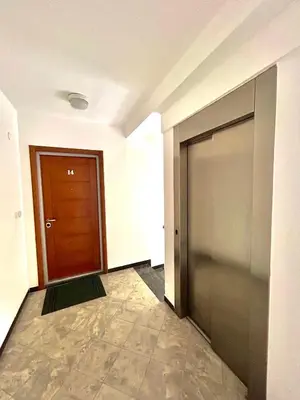an empty hallway with a door and a tile floor at Beach Bliss Apartment in Pržno