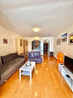 a living room with a couch and a table at Beach Bliss Apartment in Pržno