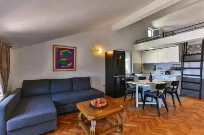 a living room with a couch and a table and a kitchen at BARBARA SVETI STEFAN in Sveti Stefan