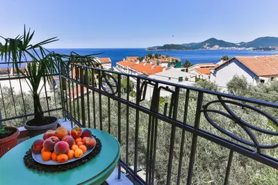 a bowl of fruit on a table on a balcony at BARBARA SVETI STEFAN in Sveti Stefan