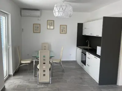 a kitchen and dining room with a table and chairs at Villa Lime in Petrovac na Moru