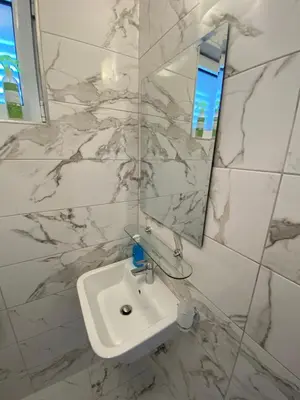 a white bathroom with a sink and a mirror at Villa Lime in Petrovac na Moru