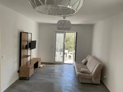 a living room with a couch and a chandelier at Villa Lime in Petrovac na Moru