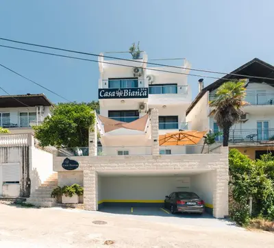 a building with a car parked in front of it at CASA BIANCA & Spa 2 in Ulcinj