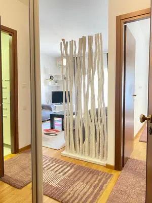 a living room with a wall of driftwood at Apartman Vesna City 2. PG in Podgorica