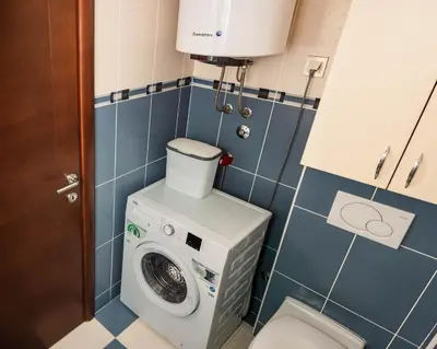 a small bathroom with a washing machine in it at Bobo Apartment in Budva
