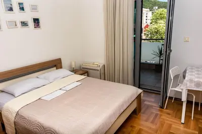 a bedroom with a bed and a balcony at Bobo Apartment in Budva