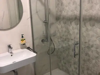 a bathroom with a shower and a sink at Stan Central point Podgorica in Podgorica