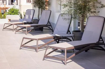 a row of chairs and tables on a patio at Vertmont Villa in Sveti Stefan