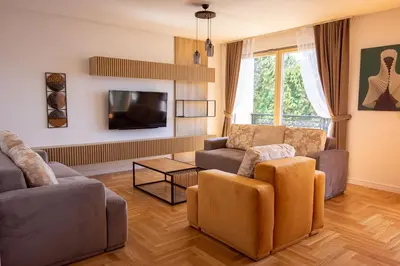 a living room with two couches and a tv at Vertmont Villa in Sveti Stefan