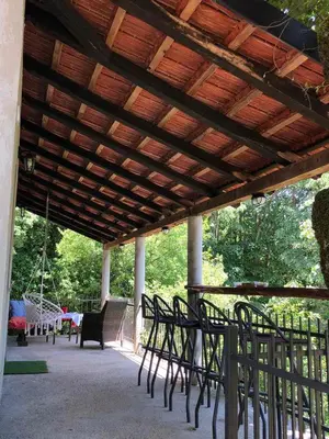 a group of chairs sitting under a wooden pergola at Bandici house in Podgorica
