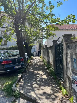 a street with a car parked next to a fence at apartman Natali in Budva