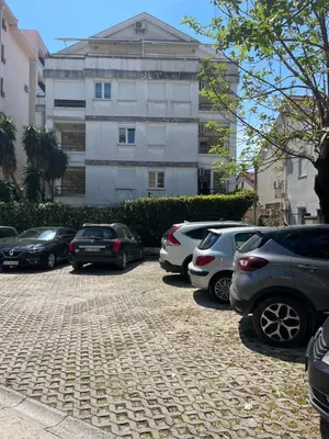 a parking lot with cars parked in front of a building at apartman Natali in Budva