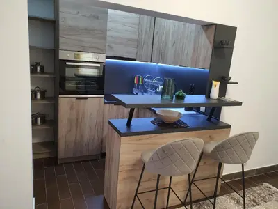 a kitchen with a blue counter and two stools at Darin in Budva