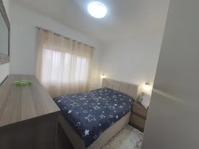 a small bedroom with a bed and a desk at Darin in Budva
