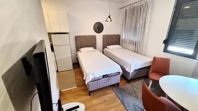 a small room with two beds and a tv at Lijepo pozicioniran stan, atrakcije blizu in Podgorica