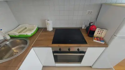 a small kitchen with a sink and a stove at Lijepo pozicioniran stan, atrakcije blizu in Podgorica