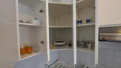 a kitchen with white shelves with utensils at Lijepo pozicioniran stan, atrakcije blizu in Podgorica