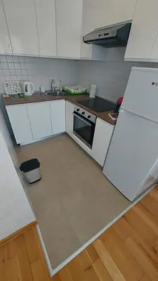 a kitchen with white cabinets and a white refrigerator at Lijepo pozicioniran stan, atrakcije blizu in Podgorica