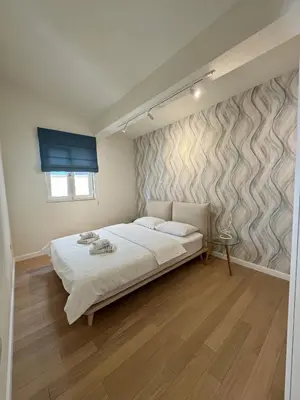a bedroom with a white bed and a wall at Point of View in Kotor