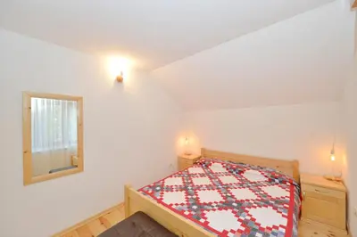 a small bedroom with a bed and a mirror at Forest house in Cetinje