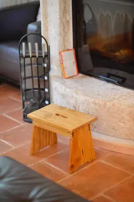 a wooden stool sitting in front of a tv at Forest house in Cetinje