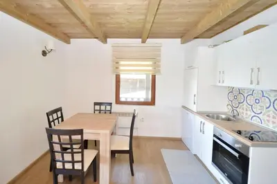 a kitchen and dining room with a wooden table and chairs at Filipa River House Ada Bojana in Ulcinj