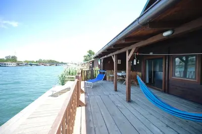 a dock with two blue hammocks on a boat at Filipa River House Ada Bojana in Ulcinj