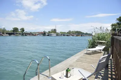 a dock with a table and chairs on the water at Filipa River House Ada Bojana in Ulcinj