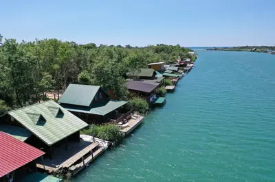 a row of houses on a dock in the water at Filipa River House Ada Bojana in Ulcinj