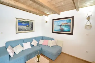 a living room with a blue couch and a clock at Filipa River House Ada Bojana in Ulcinj
