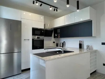 a kitchen with white cabinets and a stainless steel refrigerator at Villa Pine in Bar