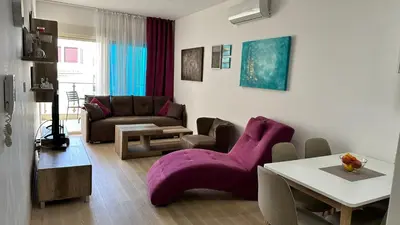 a living room with a purple chair and a table at Ambassador Apartment Bečići with Private Garage Parking in Becici
