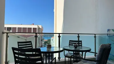 two tables and chairs on a balcony with a view at Ambassador Apartment Bečići with Private Garage Parking in Becici
