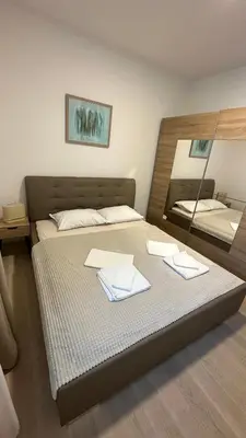 a bedroom with a large bed with a mirror at Ambassador Apartment Bečići with Private Garage Parking in Becici
